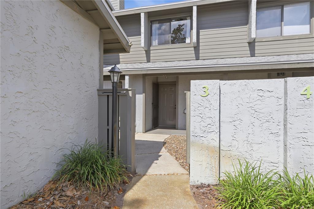 A concrete walkway leads to the entrance of a townhouse unit marked with the number 3 — 130 LIMEWOOD PLACE UNIT 3, ORMOND BEACH, FL