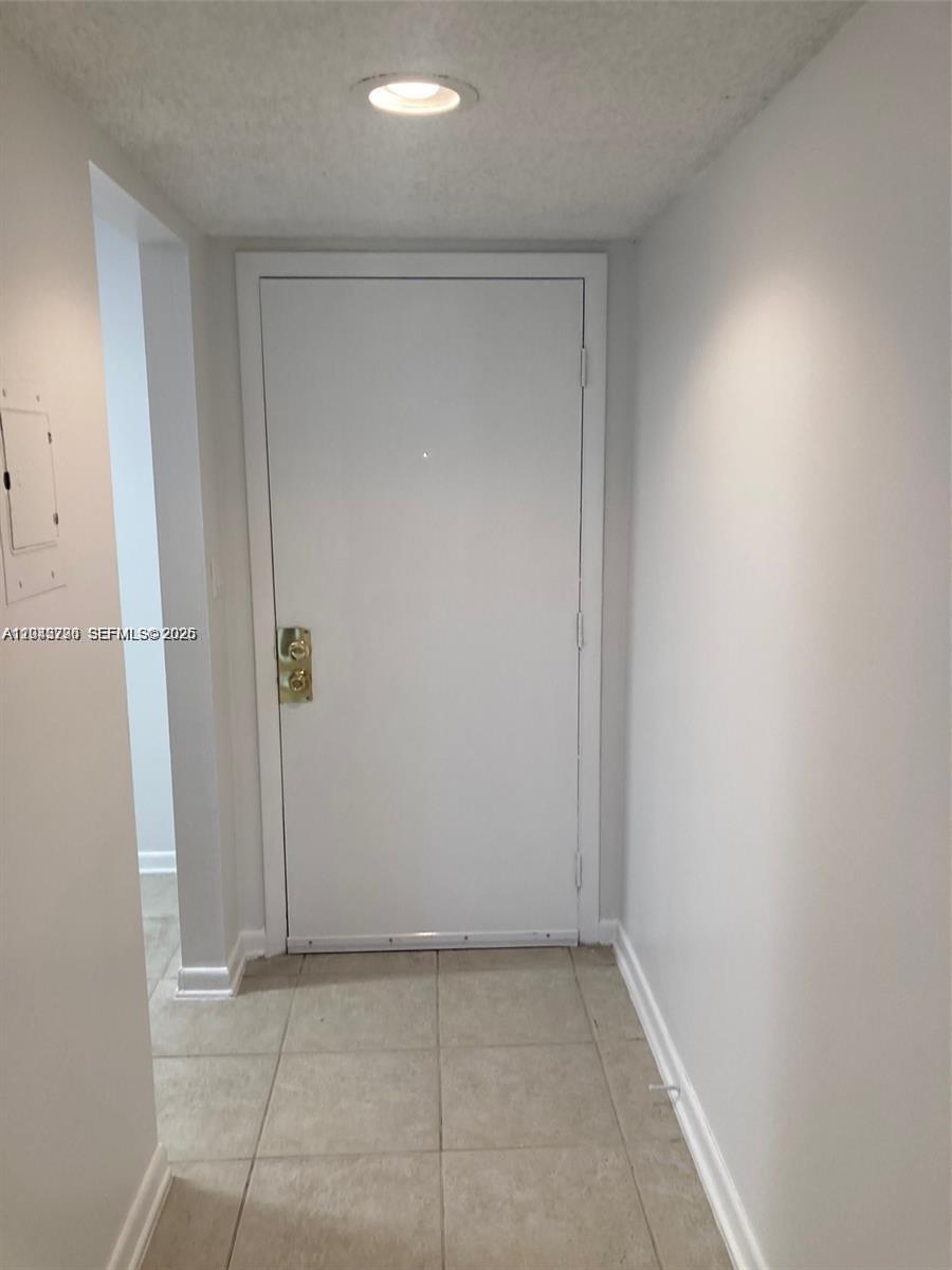 A white door with gold hardware is centered in a small, tiled entryway — 8420 SW 133rd Ave Rd # 422, Miami FL 33183, MIAMI, FL