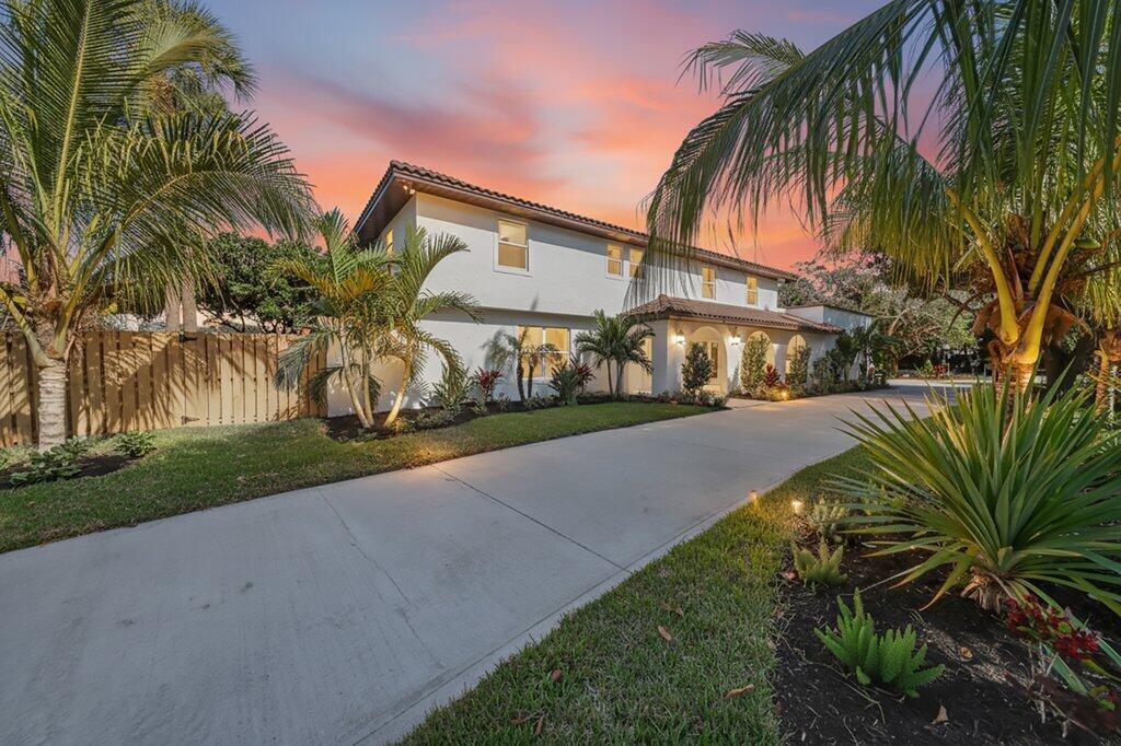 A two-story white house with a concrete driveway and palm trees at sunset — 37 E High Point Road, Sewalls Point FL 34996, SEWALLS POINT, FL