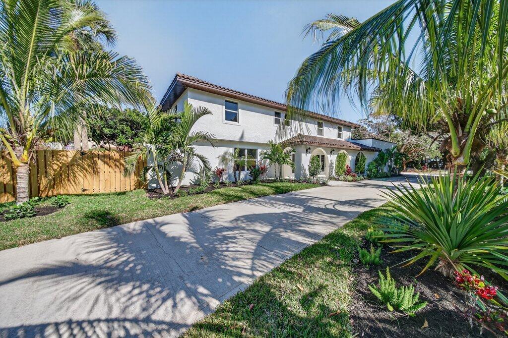 A two-story white house with a concrete driveway and palm trees in the front yard — 37 E High Point Road, Sewalls Point FL 34996, SEWALLS POINT, FL