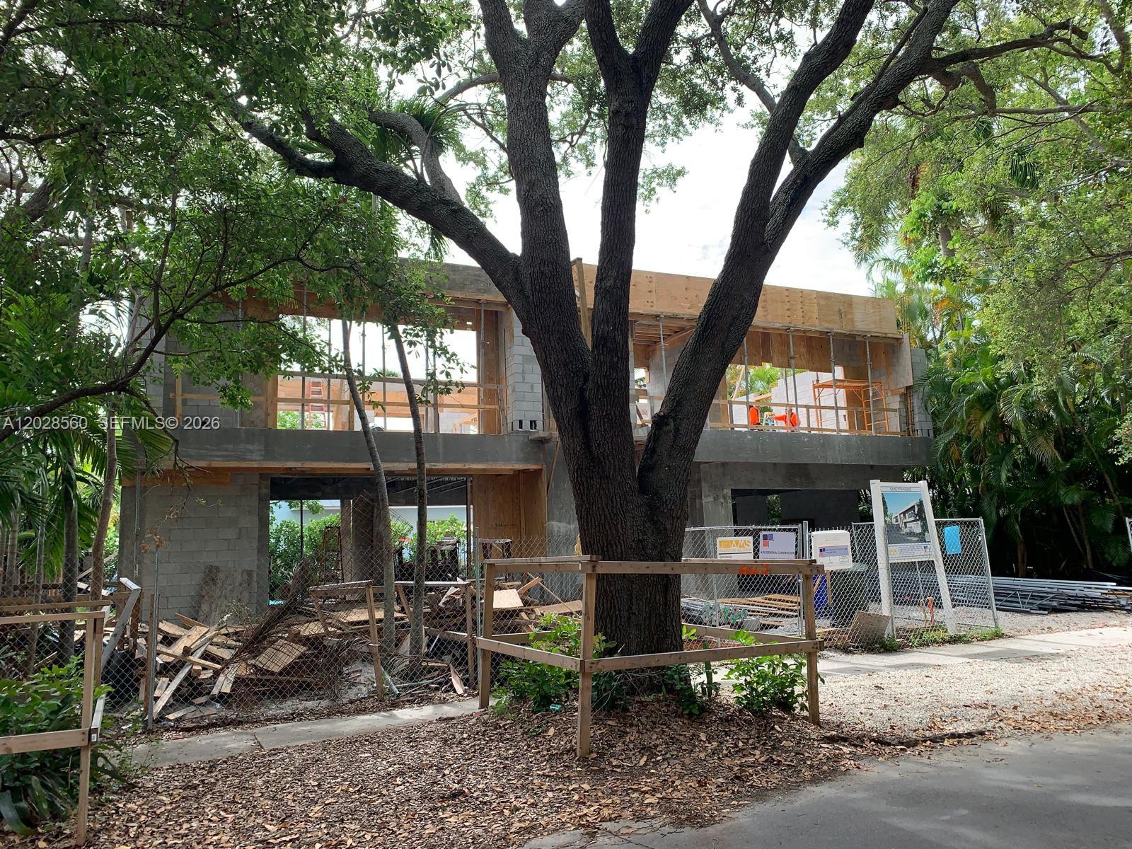 A two-story concrete residential structure under construction stands behind a large tree and fence — 428 NE 17th Ave, Fort Lauderdale FL 33301, FORT LAUDERDALE, FL