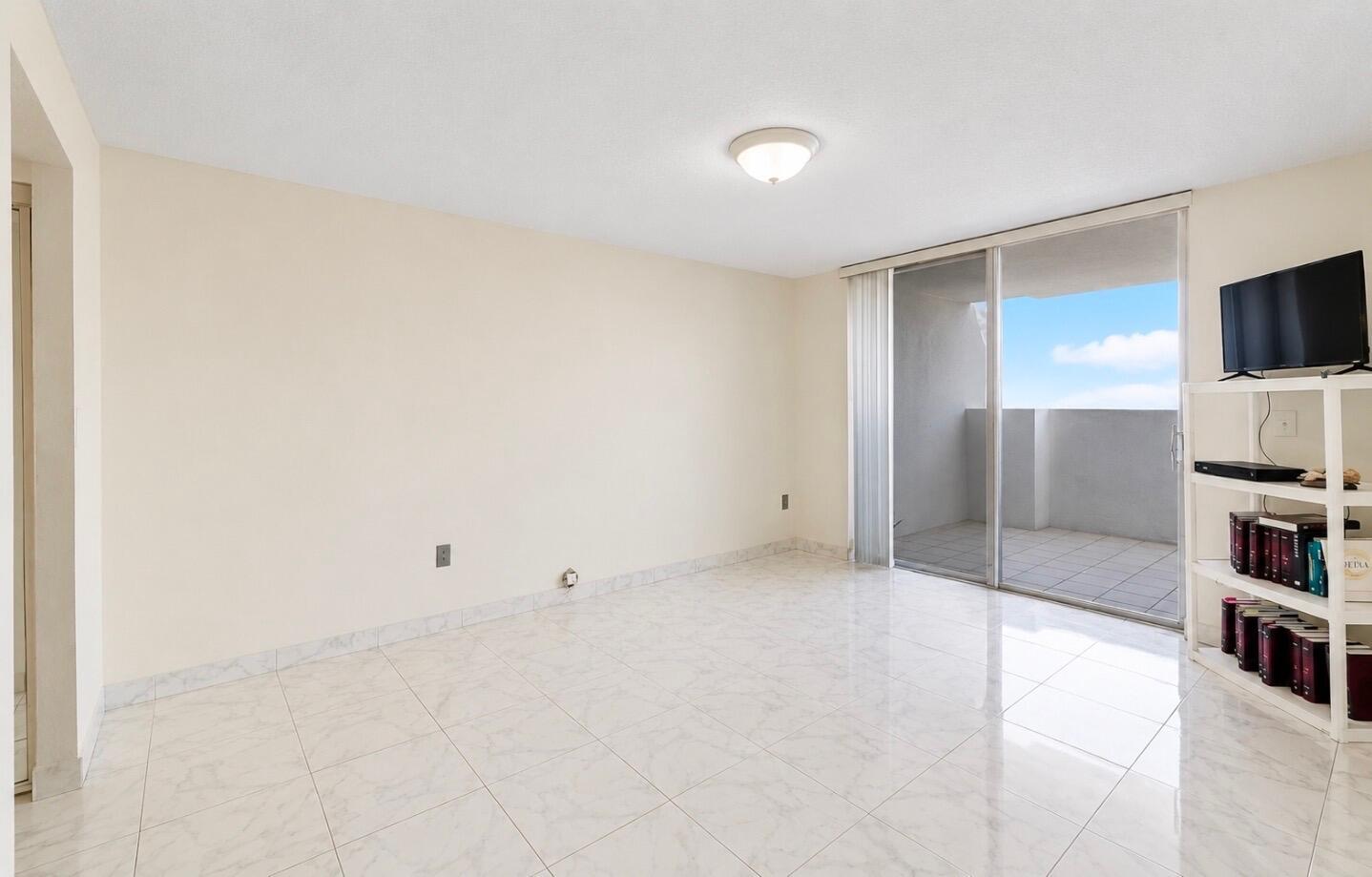 An empty room with white tile floors, a ceiling light, and a sliding glass door — 2750 NE 183rd Street Ph, Aventura FL 33160, AVENTURA, FL