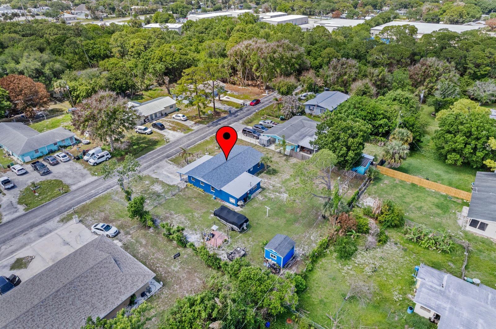An aerial view shows a blue house with a gray roof and a detached shed — 3108 Mura Drive, Fort Pierce FL 34982, FORT PIERCE, FL