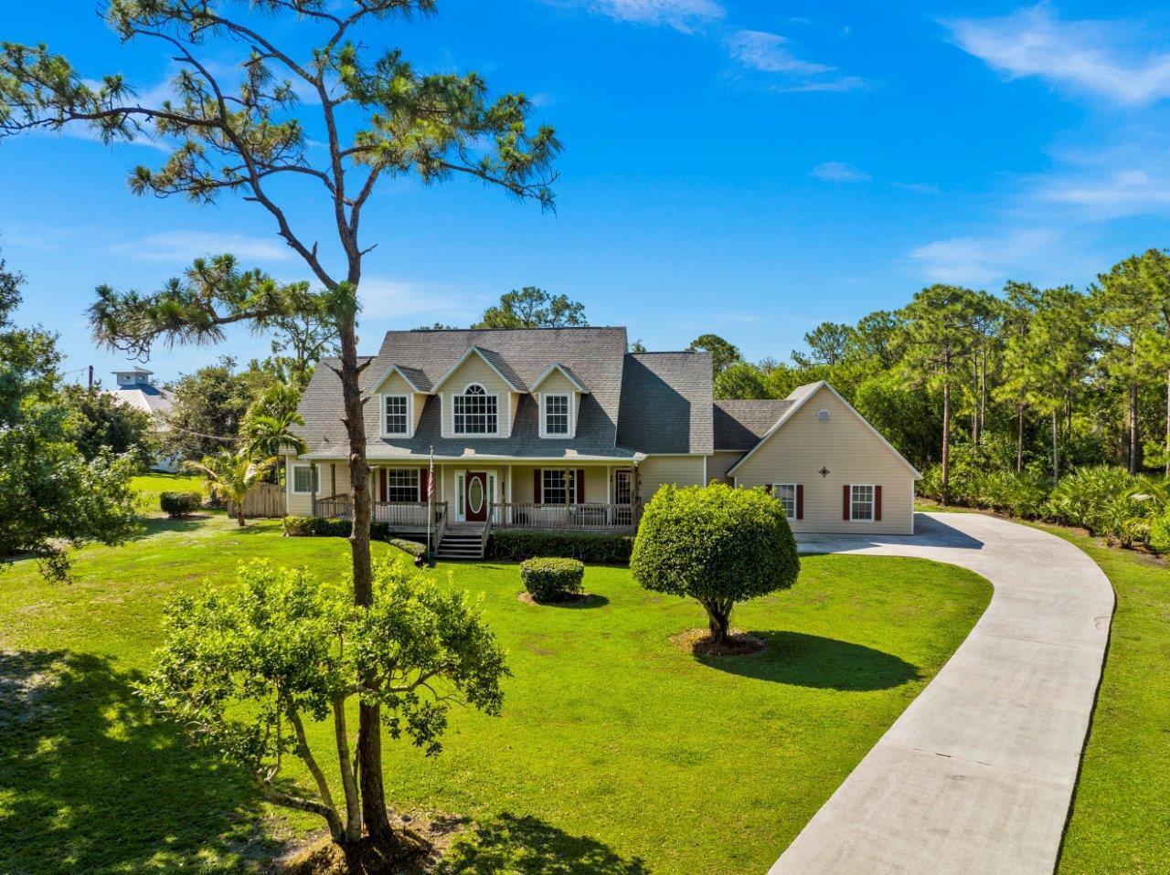 A two-story house with a front porch, dormer windows, and a long concrete driveway — 405 SE Salerno Road, Stuart FL 34997, STUART, FL