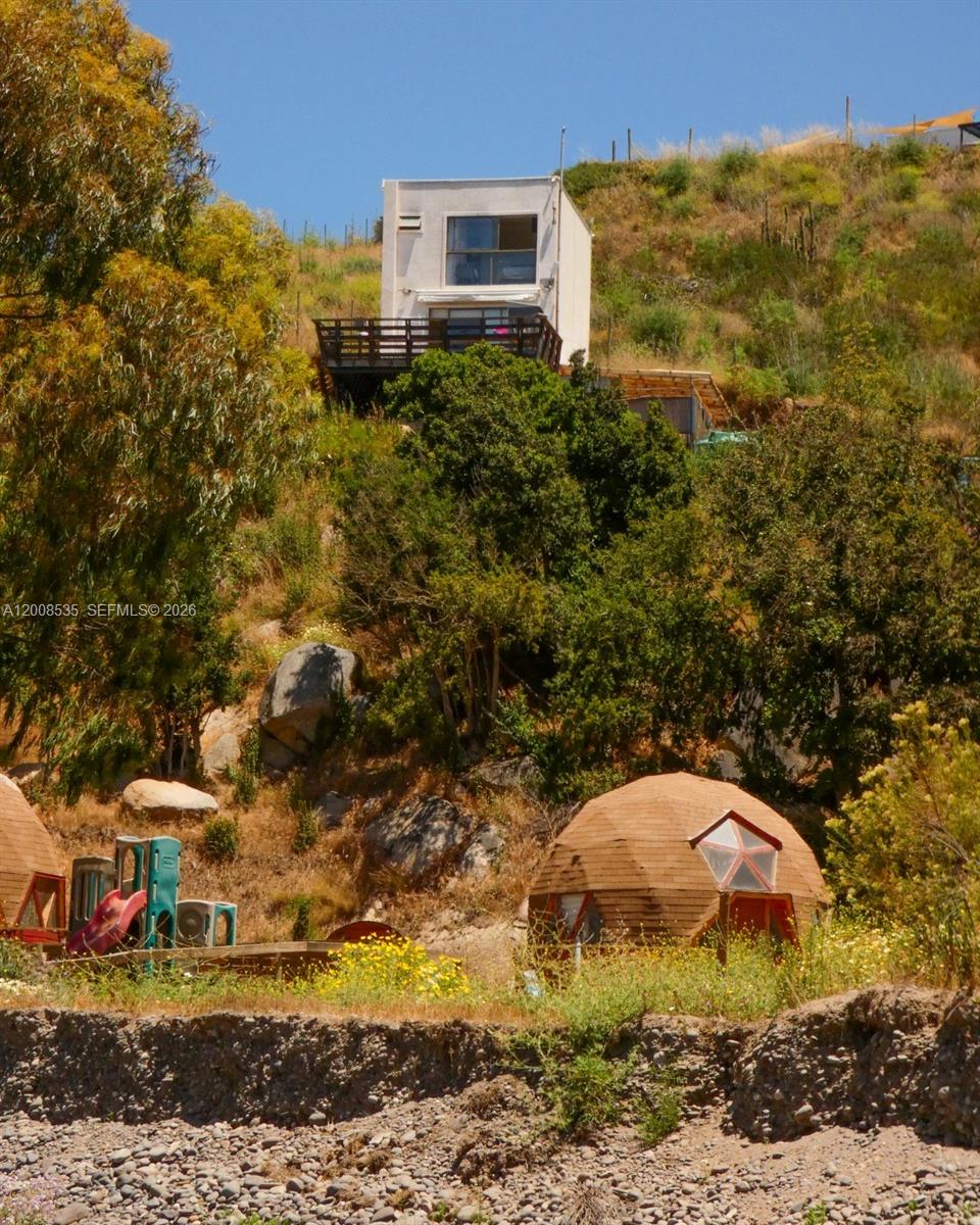 A hillside property features a modern house with a deck and a geodesic dome structure — LODGE FOR SALE Santo Domigo (Chile), 2720000, FL