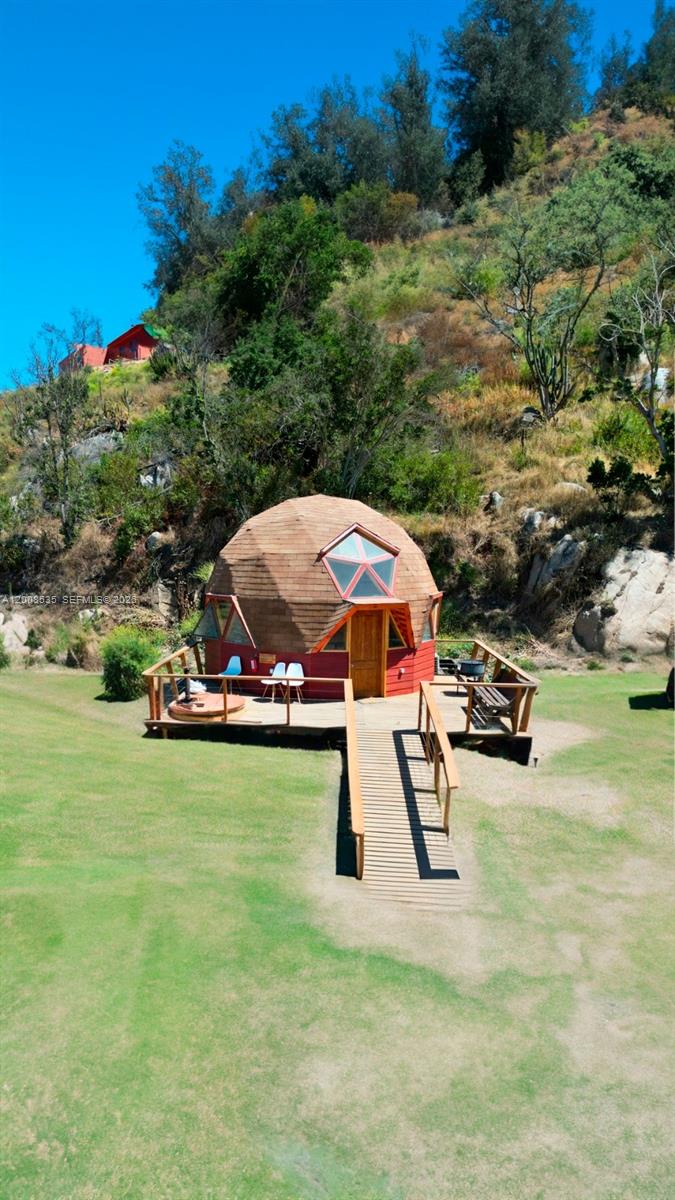 A geodesic dome cabin with a wooden deck sits on a grassy hill — LODGE FOR SALE Santo Domigo (Chile), 2720000, FL