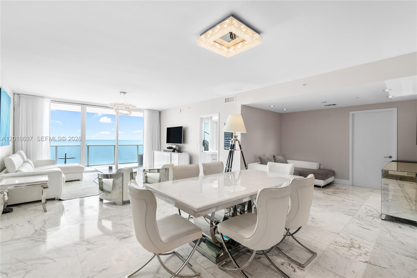 A bright, open-concept living and dining area features white marble floors and ocean views — 3951 S Ocean Dr # 1002, Hollywood FL 33019, HOLLYWOOD, FL