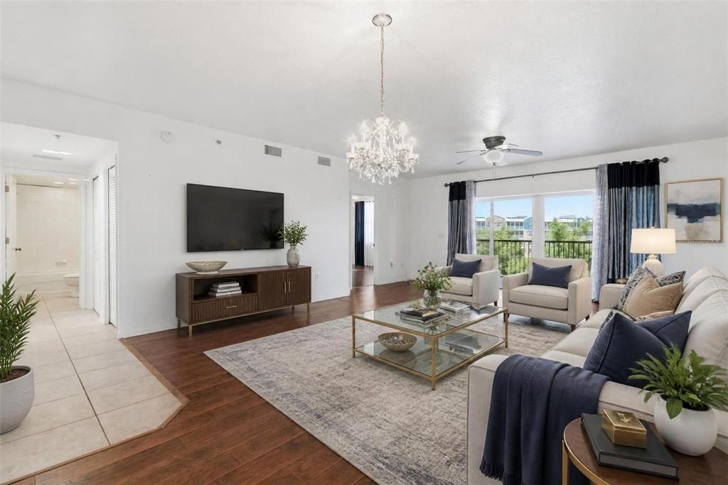 A living room with hardwood floors, a chandelier, a television, and a large area rug — 960 STARKEY ROAD UNIT 2403, LARGO, FL