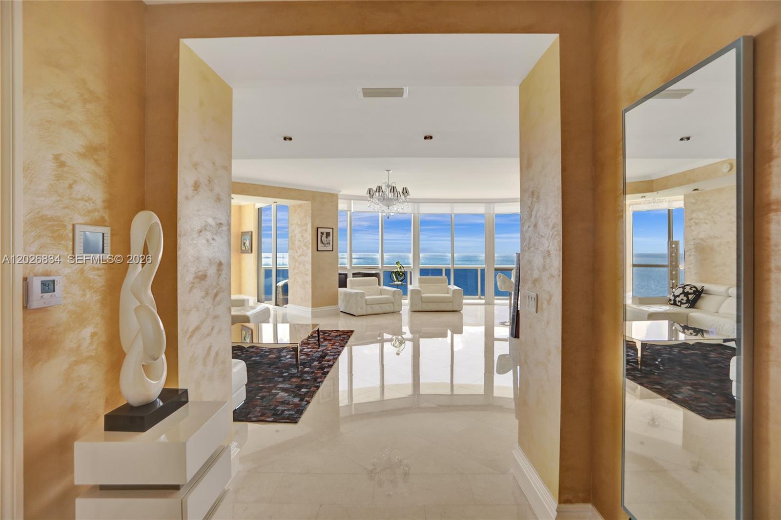 A view through a doorway into a bright living room with ocean views and tile — 18201 Collins Ave # 3309, Sunny Isles Beach FL 33160, SUNNY ISLES BEACH, FL