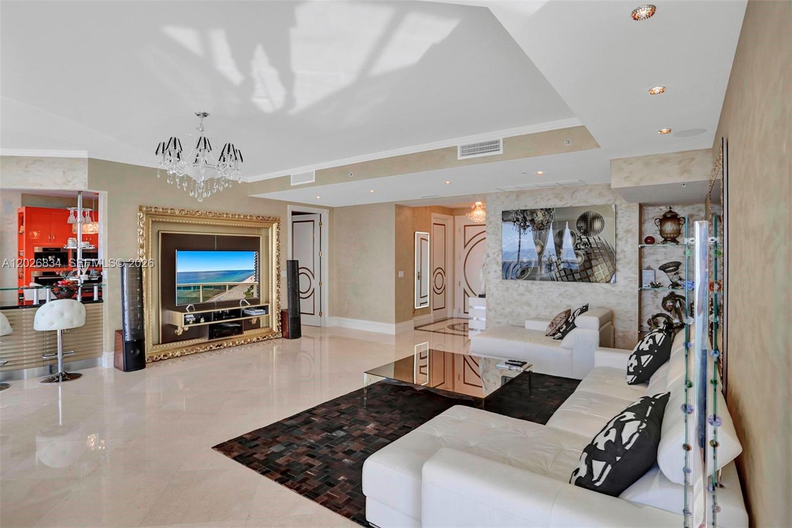 A modern living room features a white sectional sofa, a glass coffee table, and a television — 18201 Collins Ave # 3309, Sunny Isles Beach FL 33160, SUNNY ISLES BEACH, FL