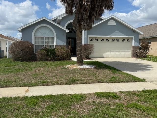 A single-story house with a light blue exterior, a two-car garage, and a palm tree — 8015 INDIAN CREEK BOULEVARD, KISSIMMEE, FL