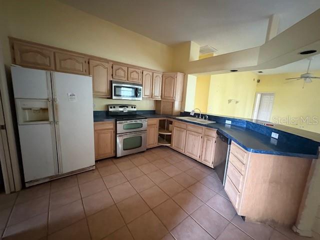 A kitchen features light wood cabinets, stainless steel appliances, and blue countertops over tile floors — 711 128TH STREET NE, BRADENTON, FL
