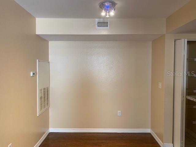 A room with beige walls, dark wood flooring, a ceiling light fixture, and a closet — 3016 PARKWAY BOULEVARD UNIT 204, KISSIMMEE, FL