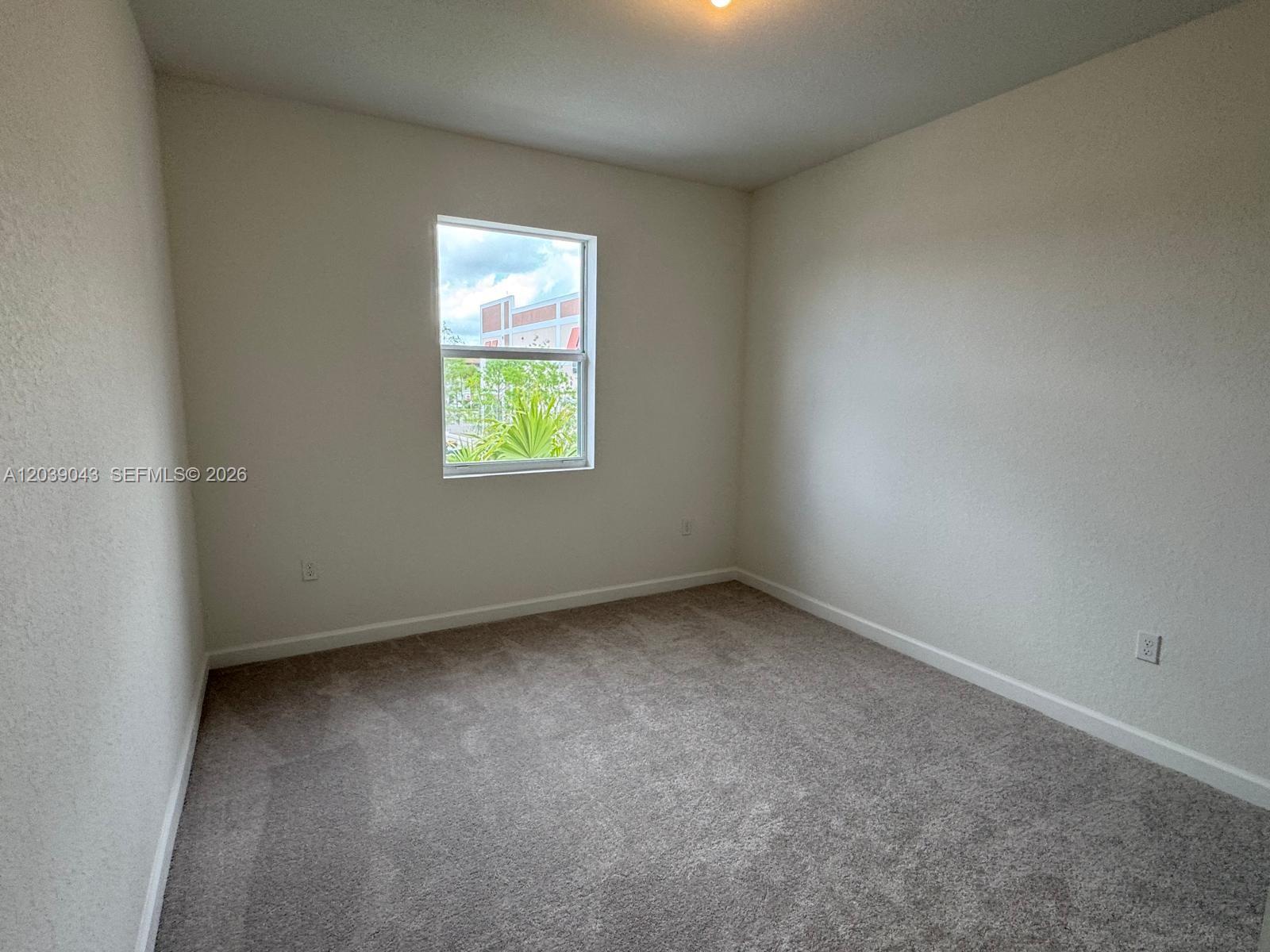 An empty bedroom features beige carpet, white walls, and a single window — 18402 SW 2nd St, Pembroke Pines FL 33029, PEMBROKE PINES, FL