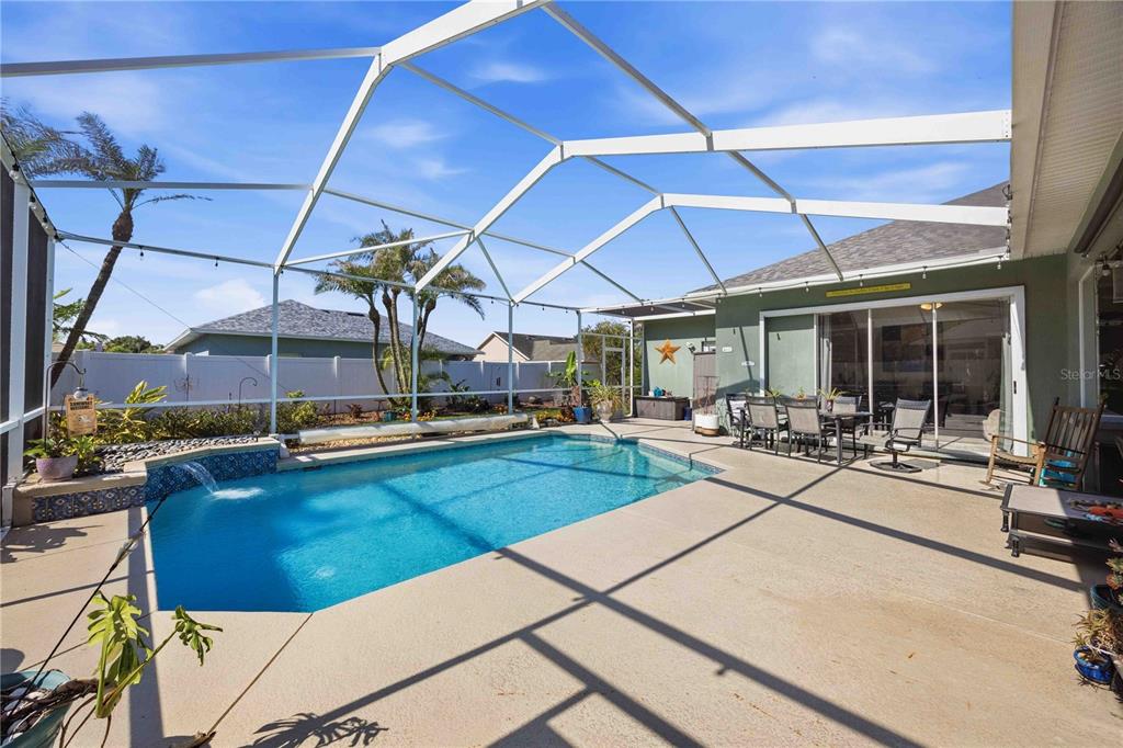 A screened-in patio features a rectangular swimming pool with a water feature and outdoor furniture — 355 RUBY LAKE LOOP, WINTER HAVEN, FL