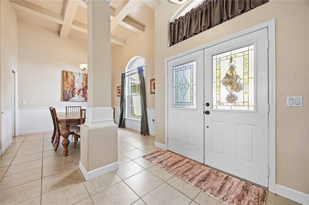 An entryway with tile flooring, a double front door, and a view of a dining area — 355 RUBY LAKE LOOP, WINTER HAVEN, FL
