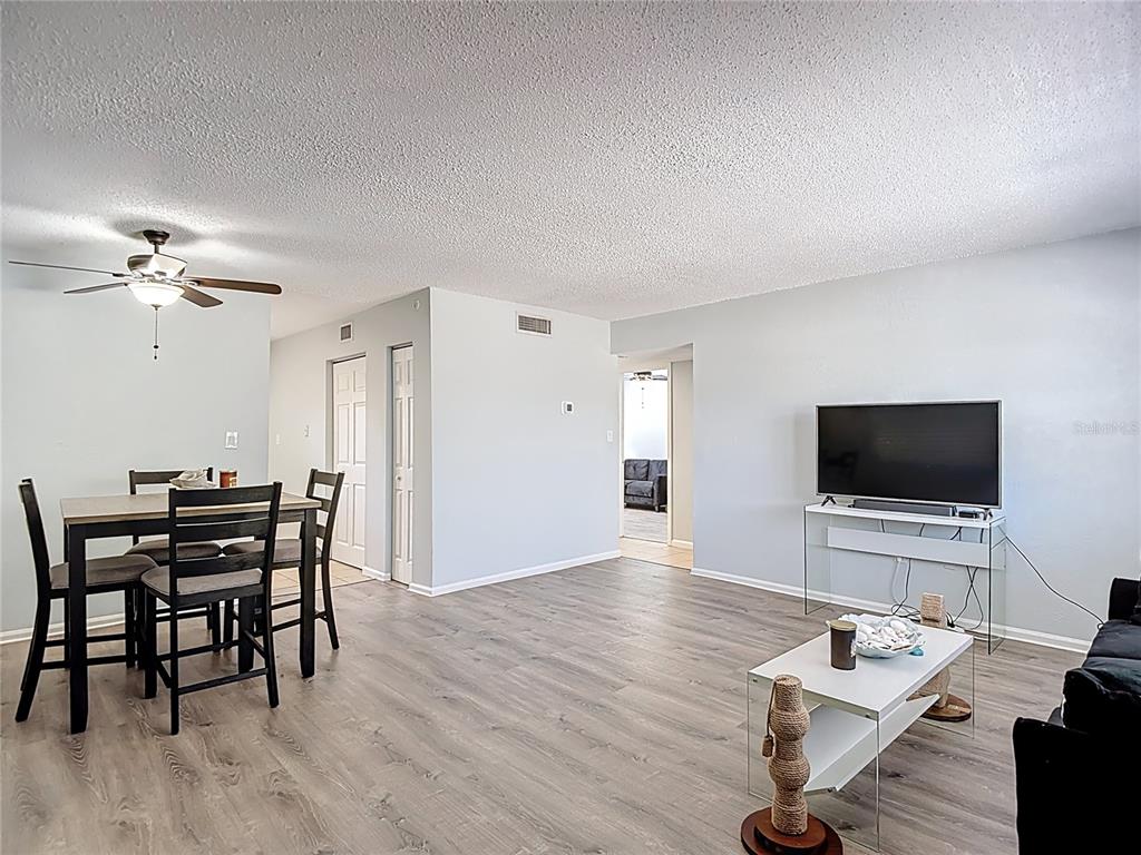 A living and dining area features light gray walls, wood-look flooring, and a ceiling fan — 201 PINE VIOLET COURT UNIT 201, TAMPA, FL