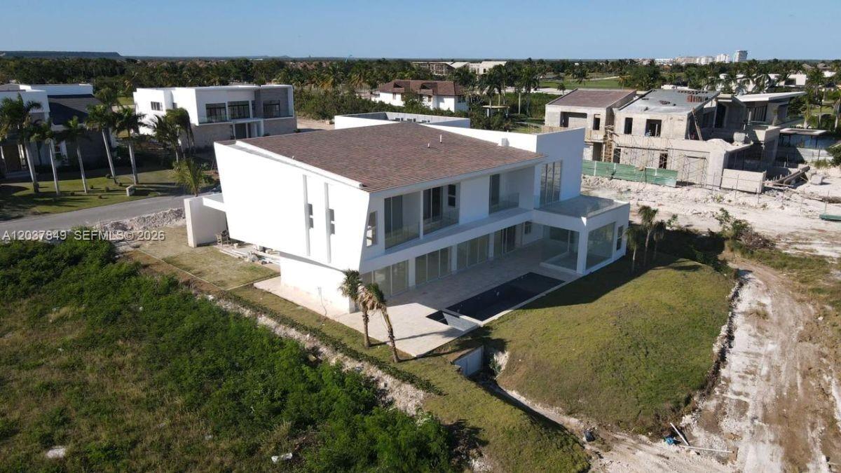 An aerial view shows a modern white two-story house with a pool and flat roof — 0 las palmitas, FL
