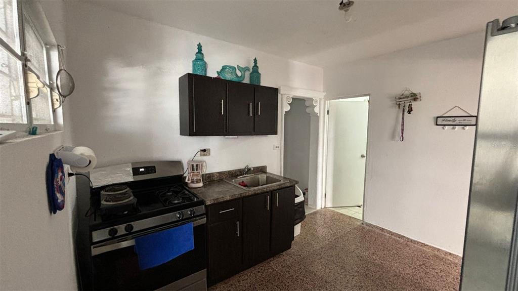 A kitchen features dark brown cabinets, a stainless steel stove, and a single-basin sink — 26 BO FACTOR 1 PARCELAS ANIMAS #399 CALLE 26, ARECIBO, PR