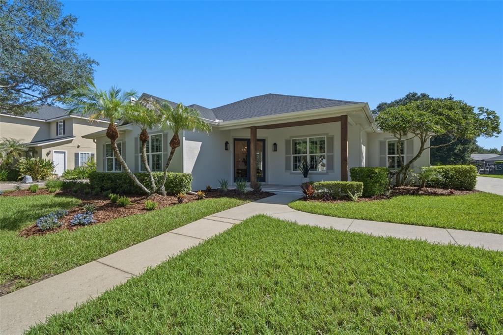 A single-story house with a covered entryway, palm trees, and a concrete walkway — 9589 PINE LILY STREET, ORLANDO, FL