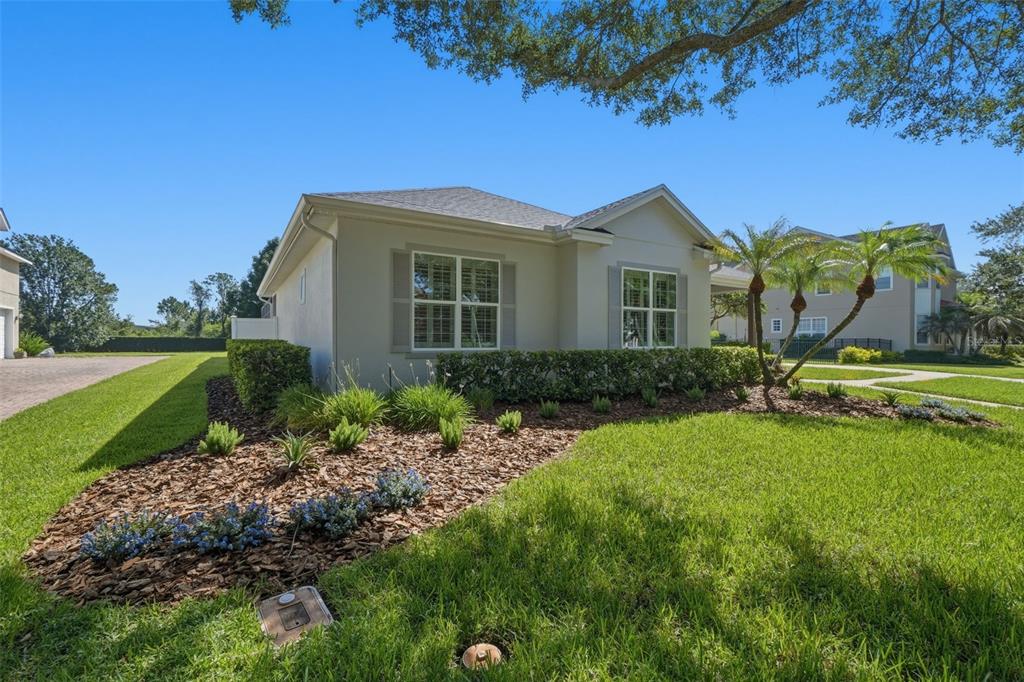 A single-story house with a beige exterior, gray shutters, and a landscaped front yard — 9589 PINE LILY STREET, ORLANDO, FL