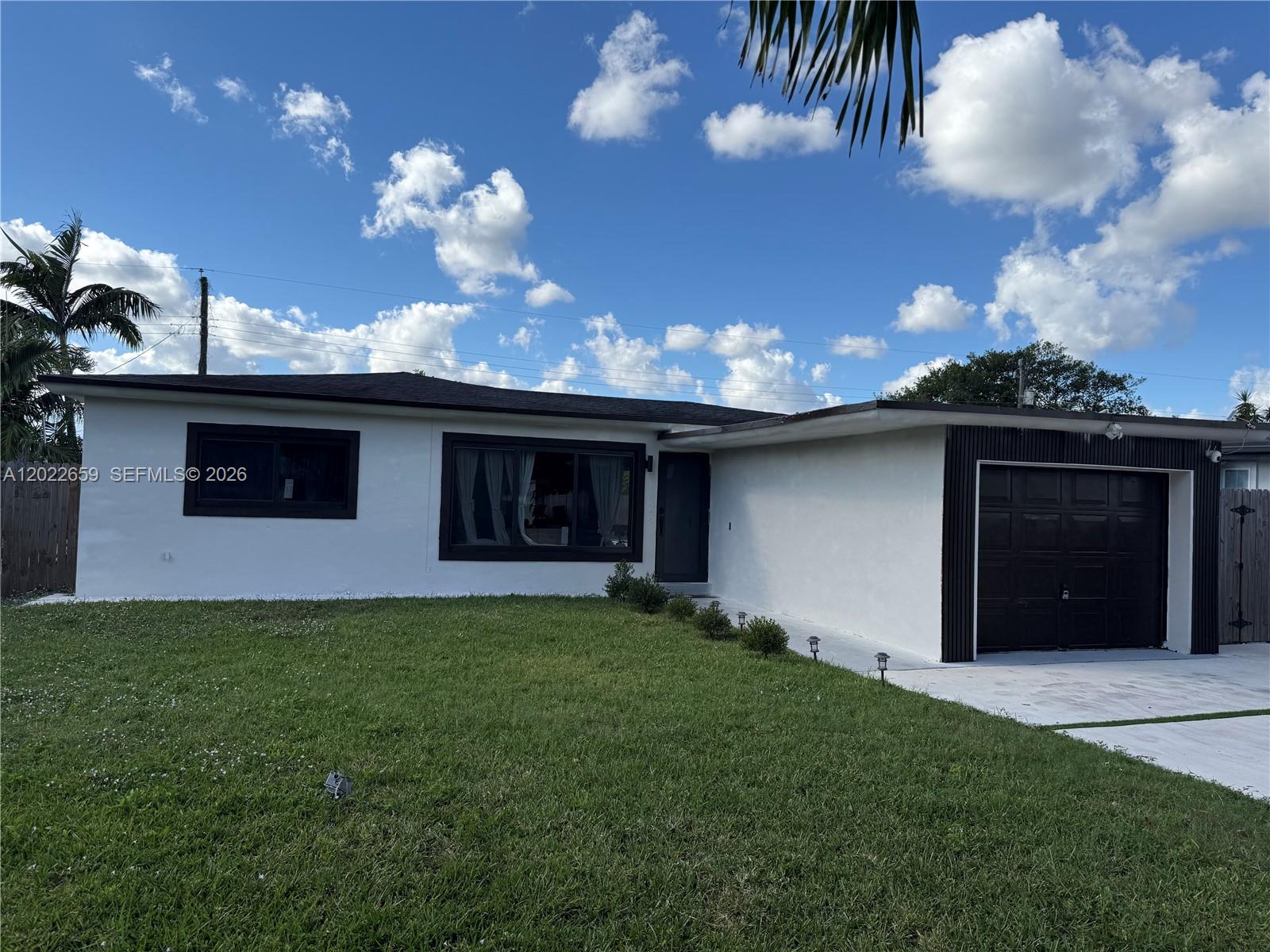 A single-story house with white stucco walls, dark trim, and a one-car garage — 1825 SW 43rd Ave, Fort Lauderdale FL 33317, FORT LAUDERDALE, FL