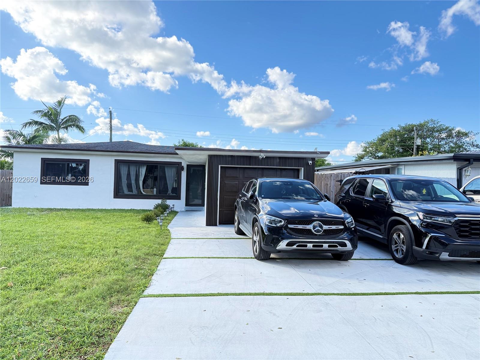 A single-story house with a white exterior, dark trim, and a concrete driveway with two cars — 1825 SW 43rd Ave, Fort Lauderdale FL 33317, FORT LAUDERDALE, FL