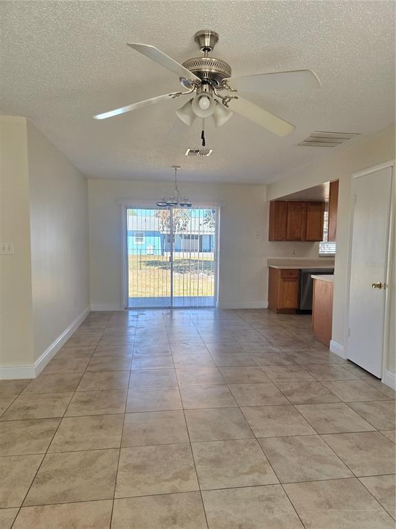 A dining area with tile flooring, a ceiling fan, and sliding glass doors to the backyard — 271 LA PAZ DRIVE, KISSIMMEE, FL