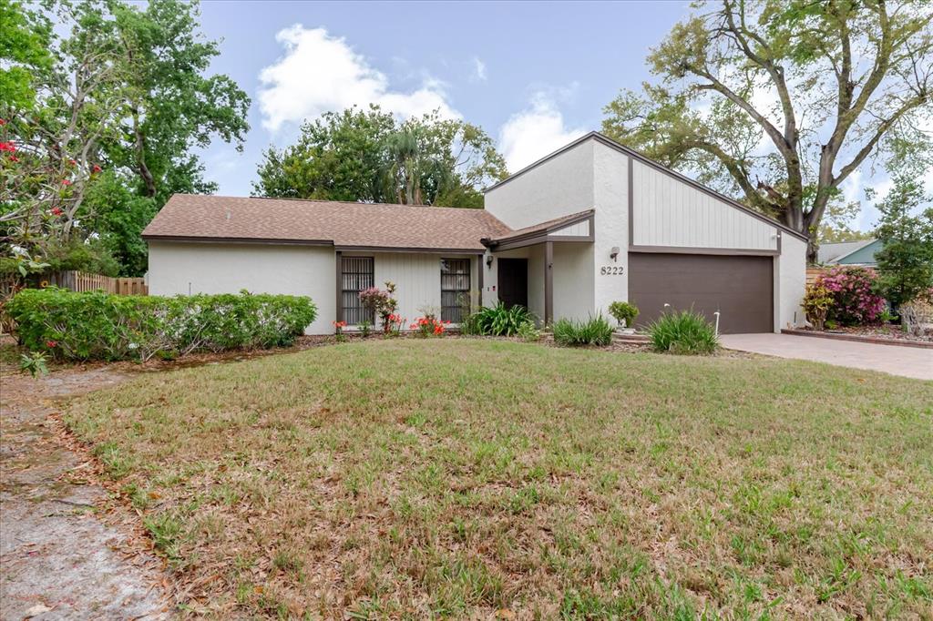 A single-story house with a brown roof, stucco siding, and an attached two-car garage — 8222 LA SERENA DRIVE, TAMPA, FL