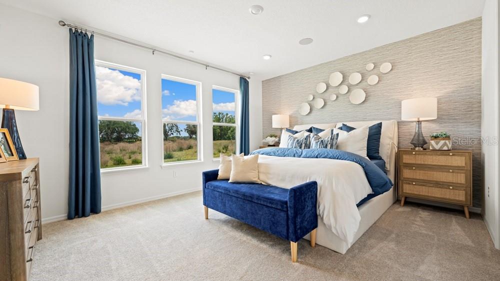 A bedroom features a blue velvet bench, a textured accent wall, and three large windows — 3512 LUMBER FALLS DRIVE, PLANT CITY, FL