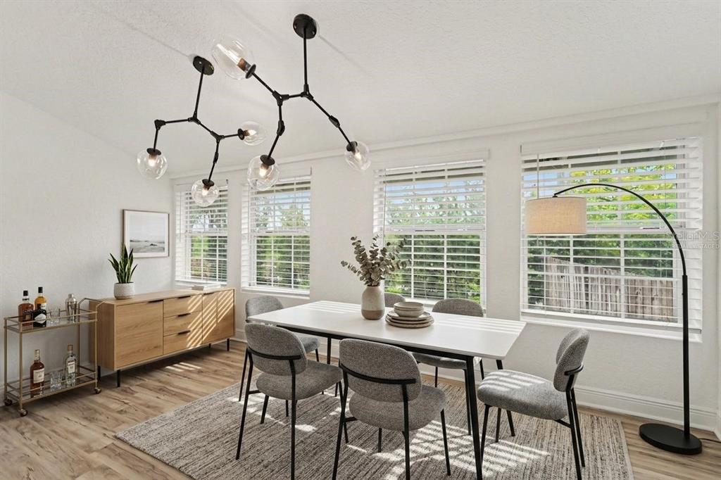 A dining room with a white table, grey chairs, a sideboard, and a modern chandelier — 800 E GENESEE STREET, TAMPA, FL