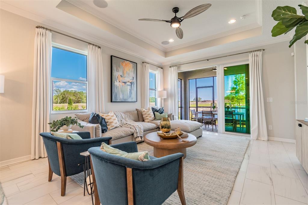 A living room features a sectional sofa, two blue armchairs, and sliding glass doors — 1606 ROYAL COURT, PORT CHARLOTTE, FL