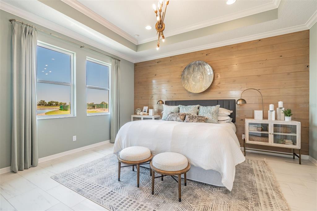 A bedroom features a wood-paneled accent wall, a tray ceiling, and two windows with curtains — 1606 ROYAL COURT, PORT CHARLOTTE, FL