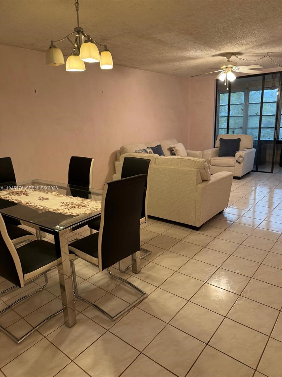 A dining area with a glass table and chairs opens into a living room — 2850 Somerset Dr # 309L, Lauderdale Lakes FL 33311, LAUDERDALE LAKES, FL