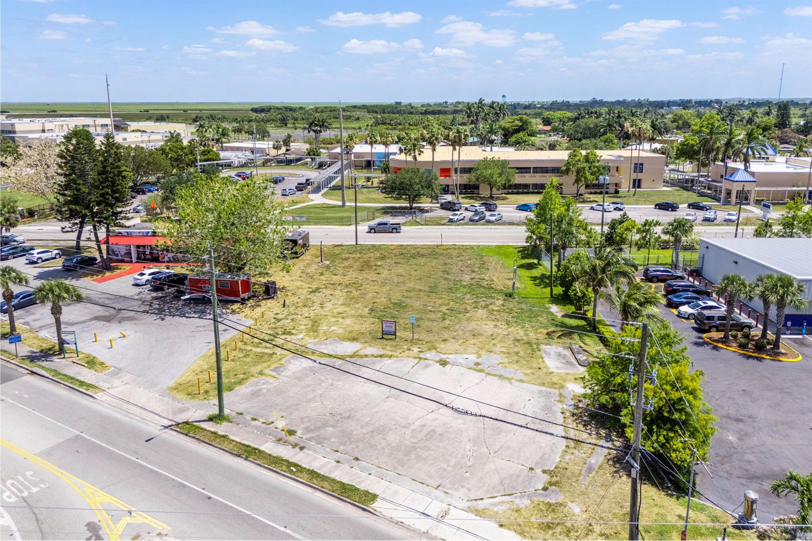 An aerial view shows a vacant lot with a concrete pad next to a road — 700 Larrimore Road, Pahokee FL 33476, PAHOKEE, FL