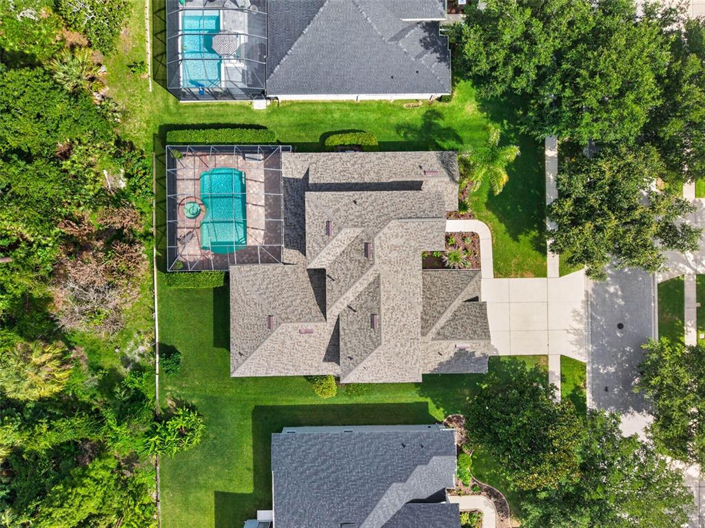 An aerial view shows a house with a screened-in pool and a concrete driveway — 5112 ABISHER WOOD LANE, BRANDON, FL