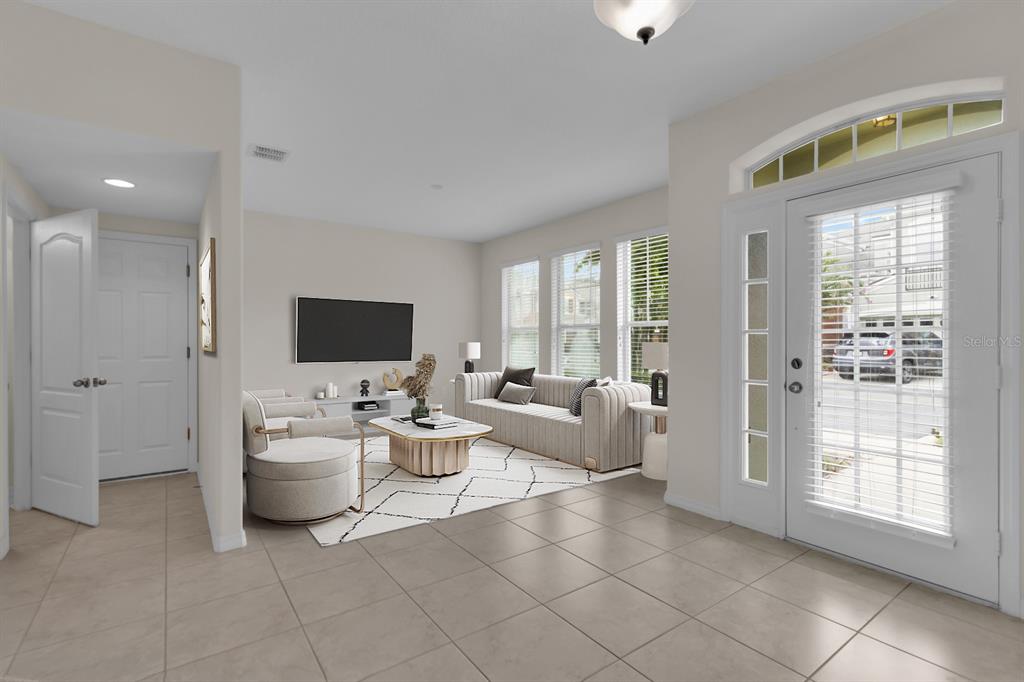 A bright living room features tile floors, a white sofa, and a glass-paned front door — 1041 LAUREL RIDGE LANE, SANFORD, FL