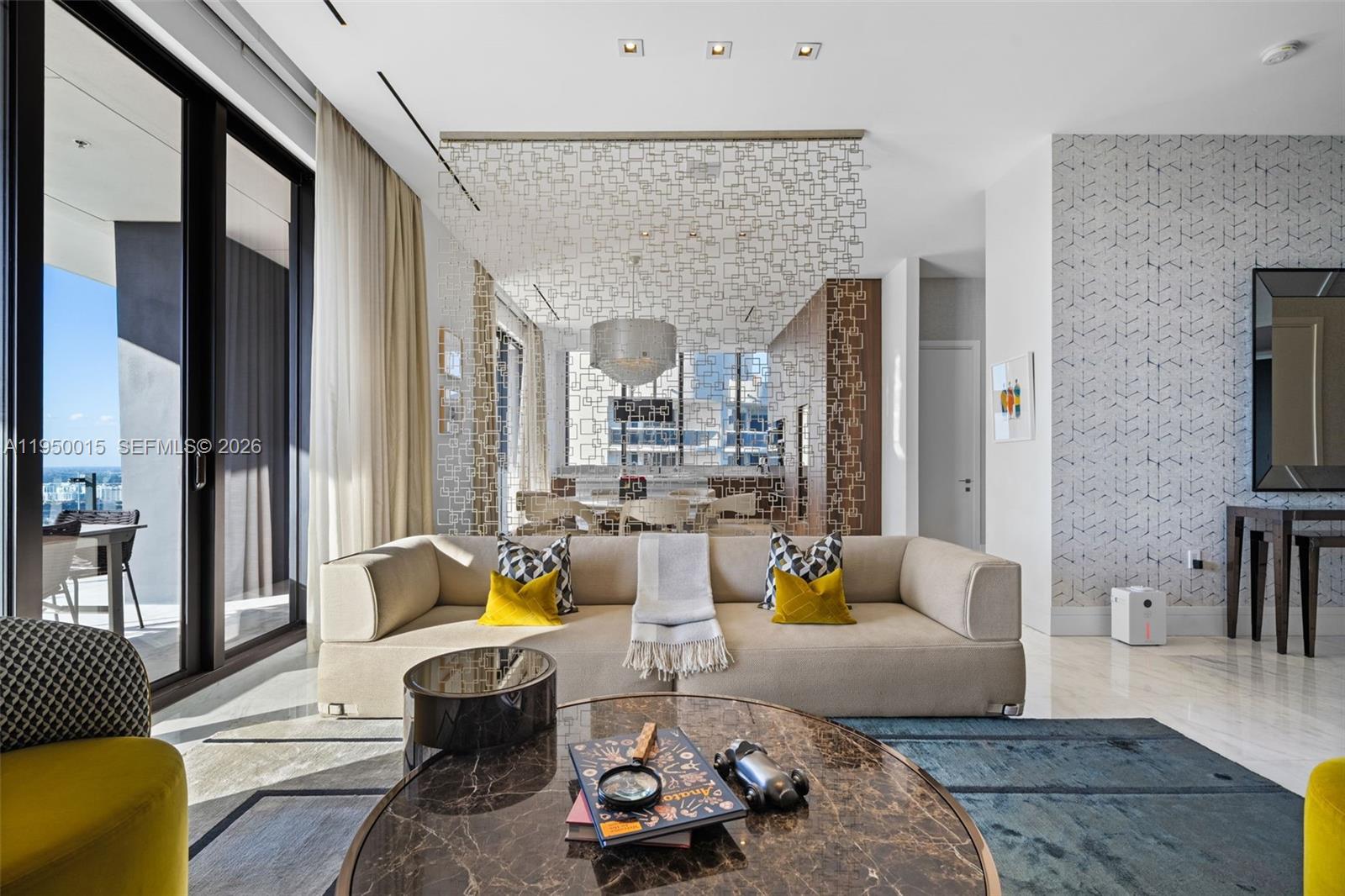 A modern living room features a beige sofa, a patterned room divider, and marble flooring — 17141 Collins Ave # 3002, Sunny Isles Beach FL 33160, SUNNY ISLES BEACH, FL
