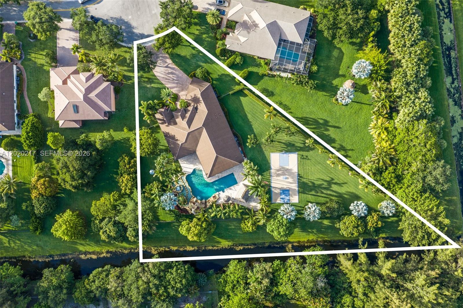 An aerial view shows a house with a pool and basketball court on a lot — 10018 Laurel Rd, Davie FL 33328, DAVIE, FL