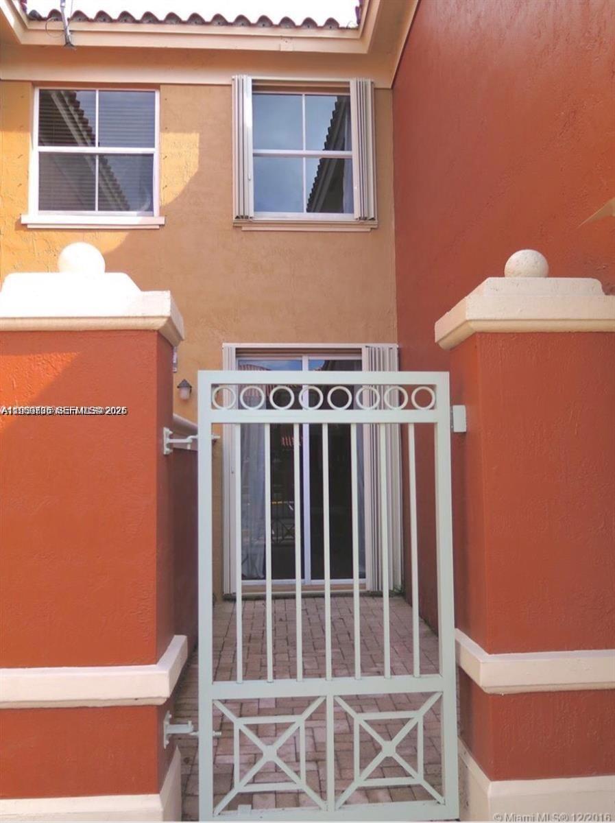 A light-colored metal gate stands in front of a patio entrance with orange walls — 11479 NW 60th Ter # 373, Doral FL 33178, DORAL, FL