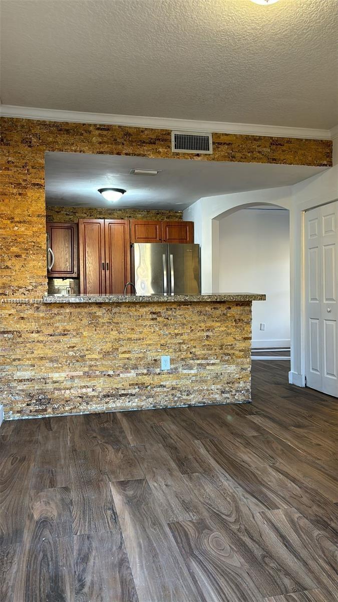 A kitchen with a stone-tiled breakfast bar, wood-look flooring, and stainless steel appliances — 11479 NW 60th Ter # 373, Doral FL 33178, DORAL, FL