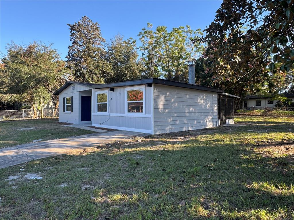 A light gray, single-story house with a flat roof and a concrete driveway — 7224 VALIANT COURT, ORLANDO, FL