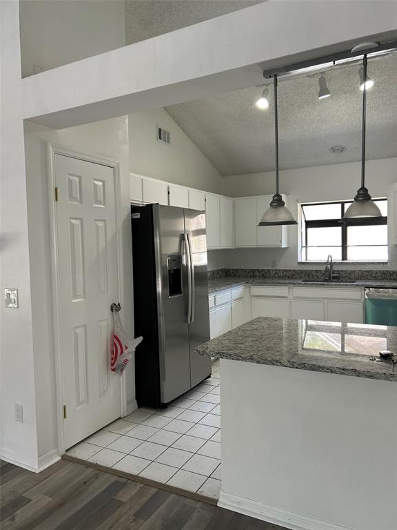 A kitchen features white cabinets, granite countertops, stainless steel appliances, and a tiled floor — 5106 STONEHURST ROAD, TAMPA, FL