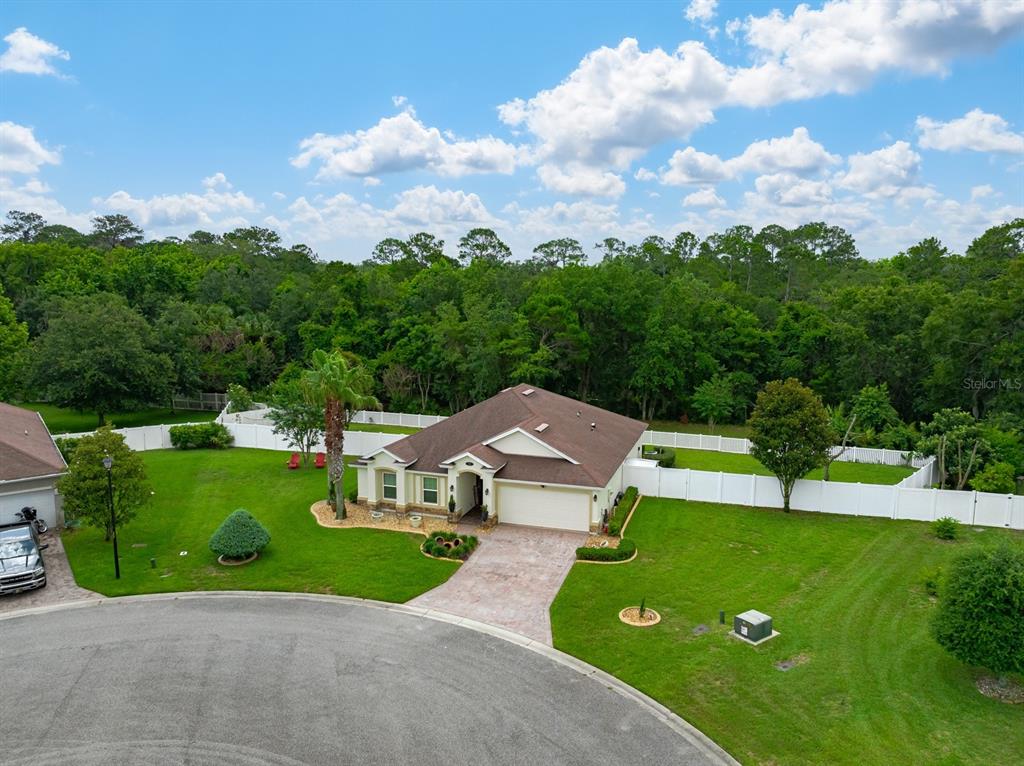 An aerial view of a single-story house with a white fence and large backyard — 53 AUBERRY DRIVE, PALM COAST, FL
