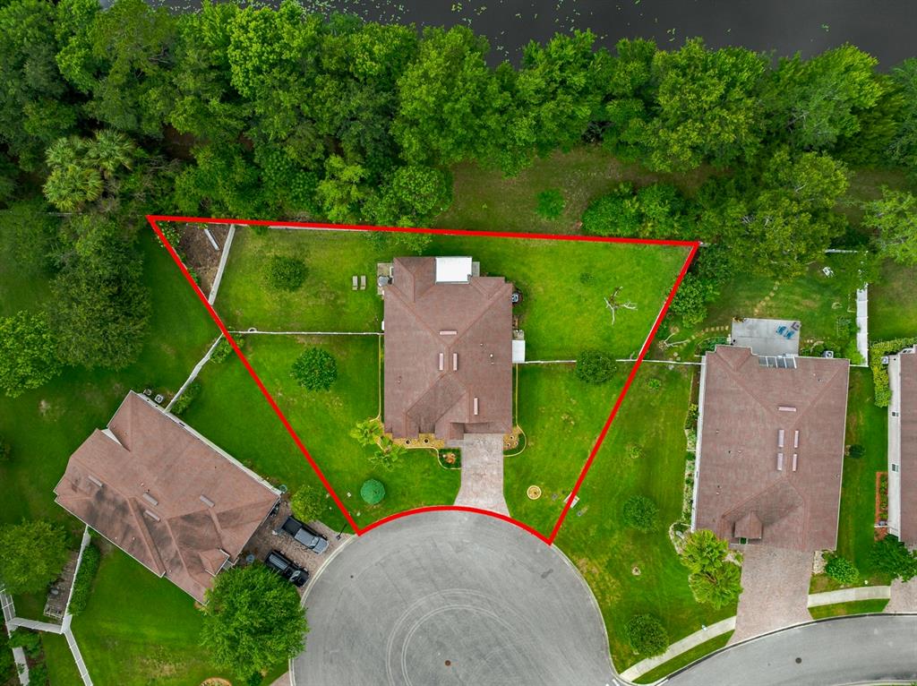 An aerial view shows a house with a brown roof on a large, triangular lot — 53 AUBERRY DRIVE, PALM COAST, FL