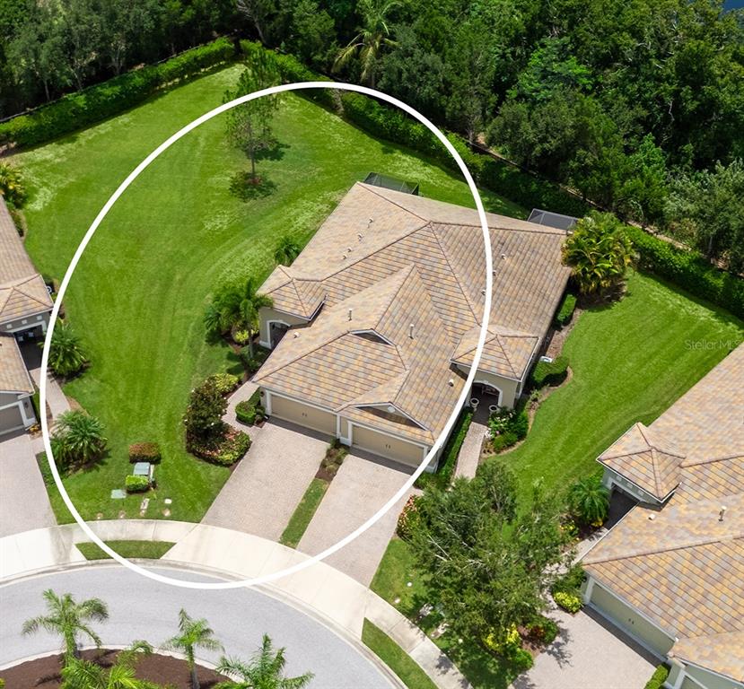 An aerial view shows a single-family home with a large side yard and driveway — 4866 MAYMONT PARK CIRCLE, BRADENTON, FL