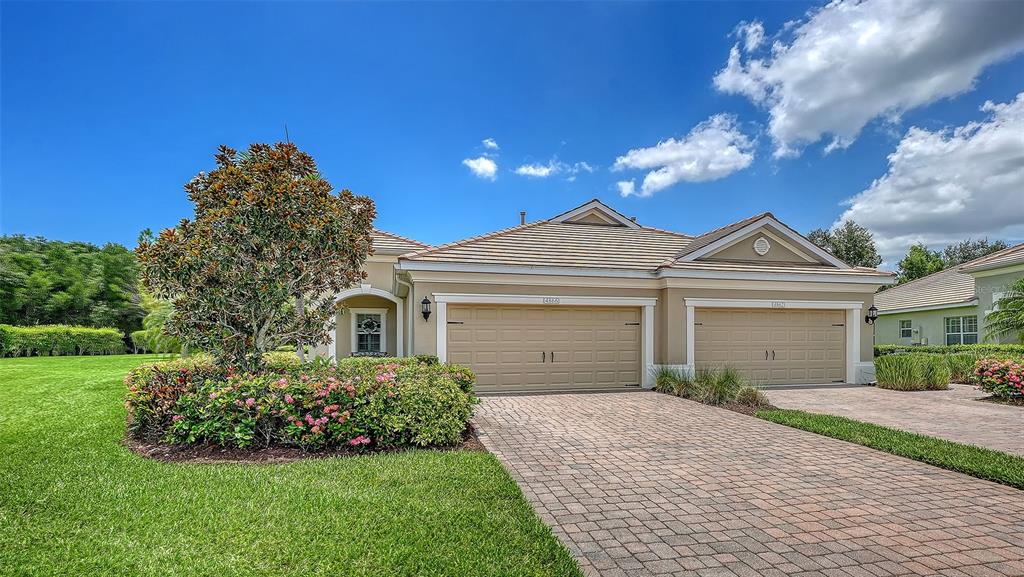 A single-story house with a two-car garage and a landscaped front yard — 4866 MAYMONT PARK CIRCLE, BRADENTON, FL