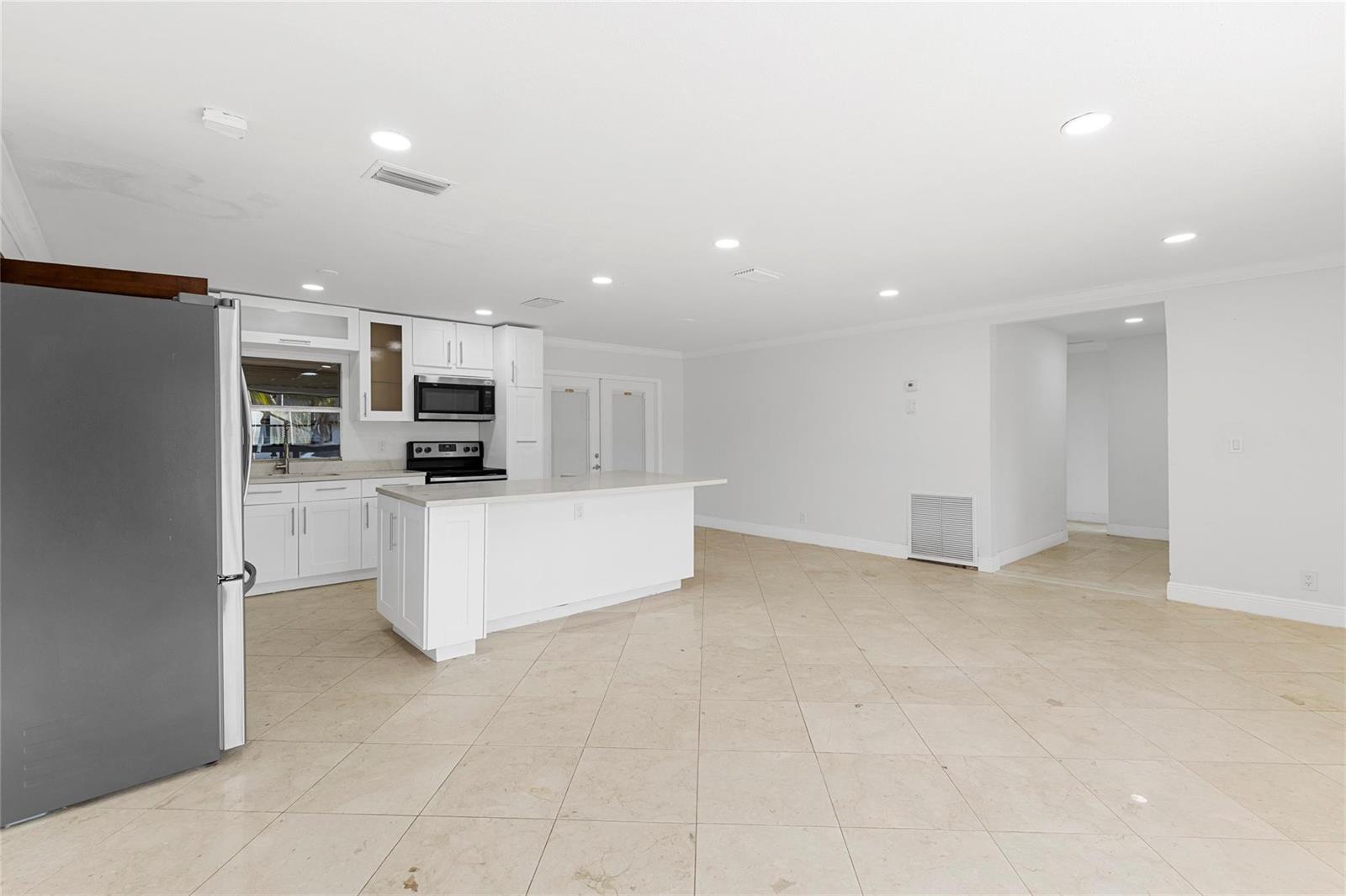 A white kitchen with an island, stainless steel appliances, and tile flooring in an open space — 3313 SW 19th Street, Fort Lauderdale FL 33312, FORT LAUDERDALE, FL