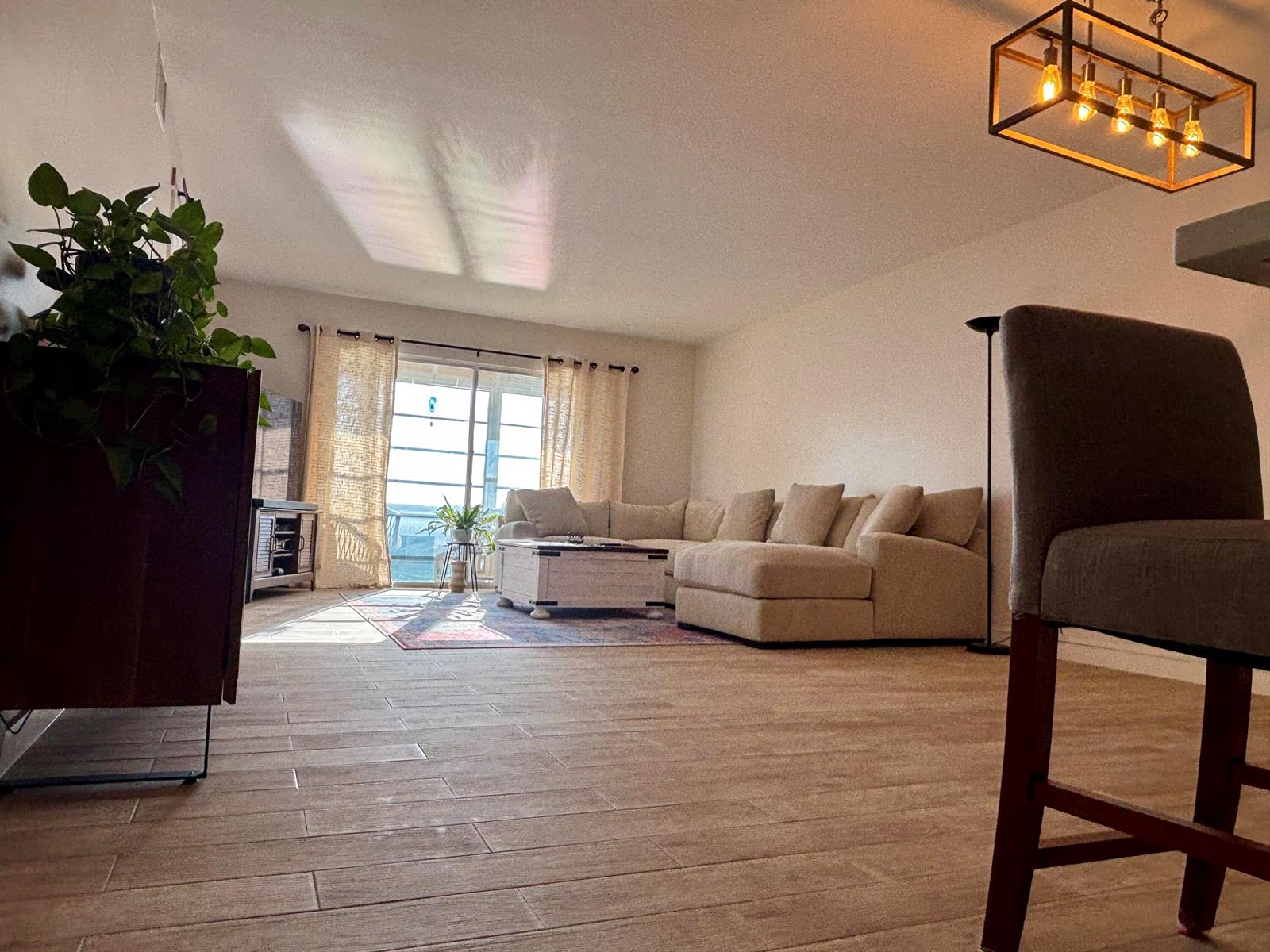 A living room features light-colored tile flooring, a sectional sofa, and a modern rectangular chandelier — 1501 SW 134th Way Unit 304, Pembroke Pines FL 33027, PEMBROKE PINES, FL