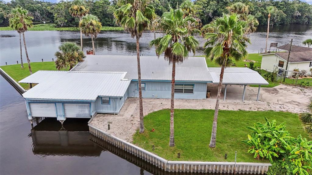 A covered boat slip with wooden framing, a metal roof, and two roll-up garage doors — 56440 WATER OAK ROAD, ASTOR, FL